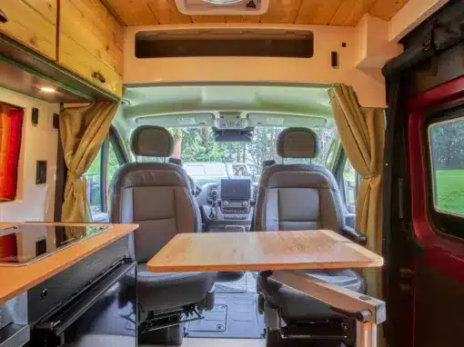 Beautiful interior of a professionally converted off-grid ready RAM ProMaster van from the team of Camp N Car located in Port Townsend on Washington's Olympic Peninsula swivel seats and Lagun table